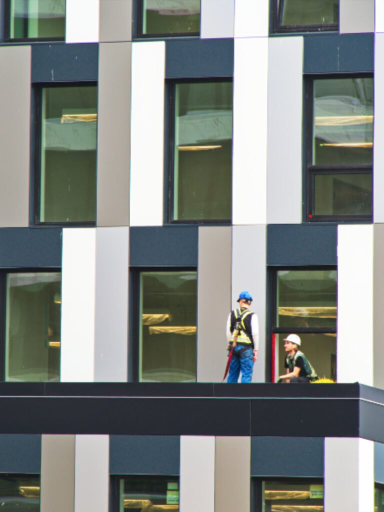 Roofers working on scaffolding against a building