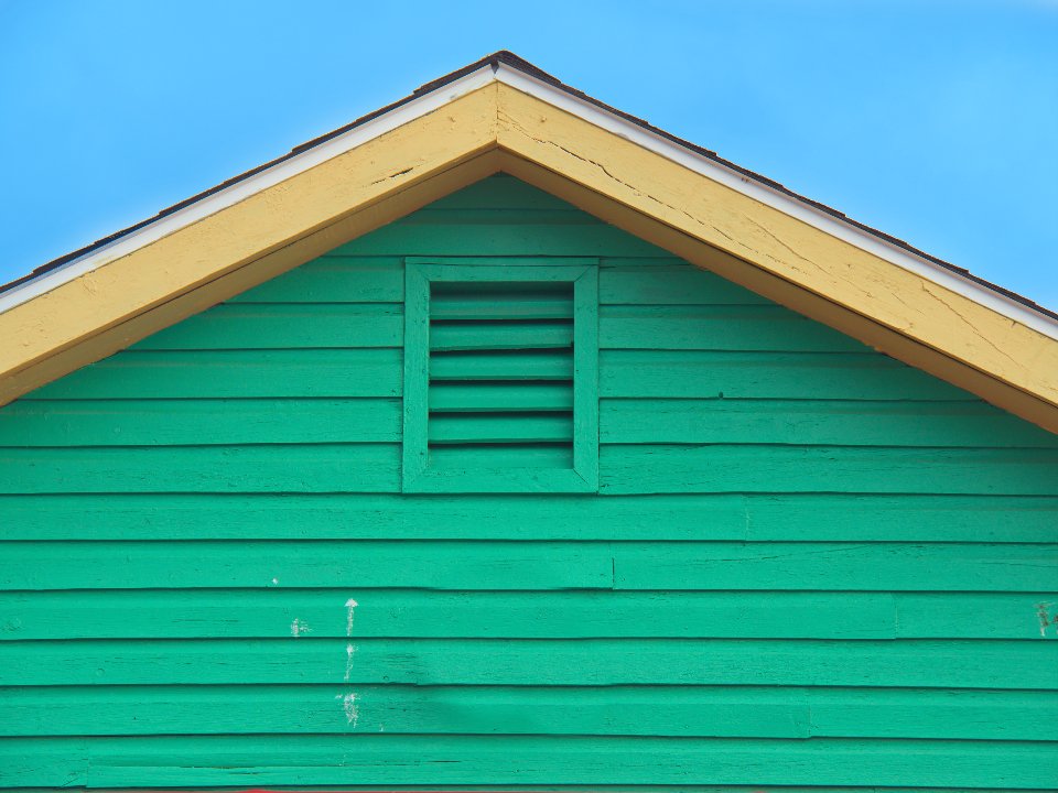 A green gable with white trim and a gutter line
